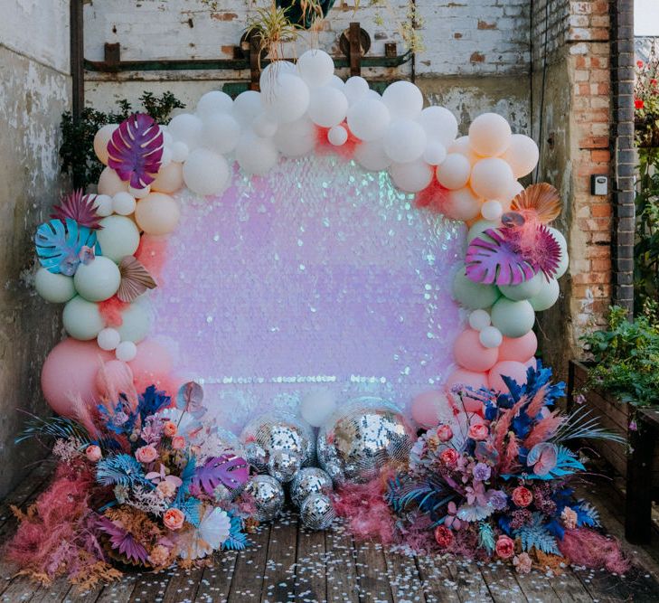 Altar back drop with sequin sheet, balloon installation and glitter balls 