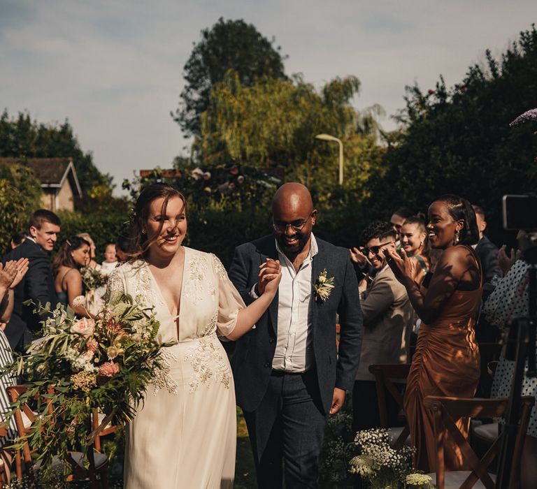 Bride and groom descending the aisle as husband and wife 