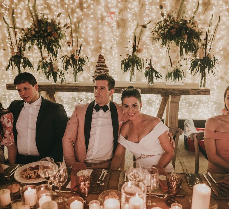 Bride and groom at the top table with a fairy light curtain backdrop 