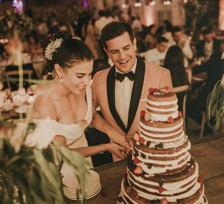 Bride and groom cutting the semi naked wedding cak e