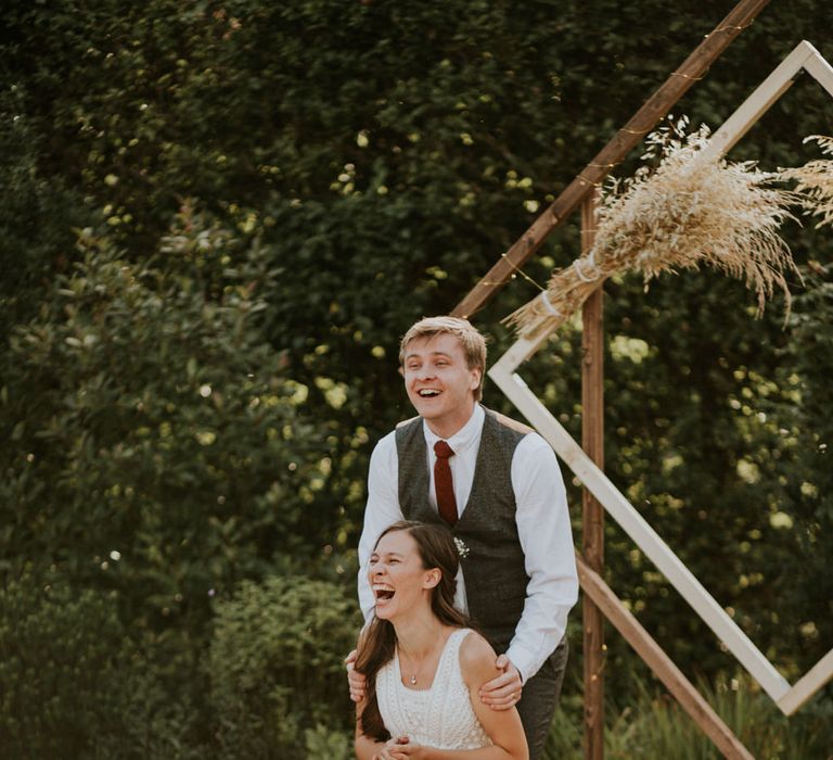 Bride and groom laughing during the outdoor wedding speeches 