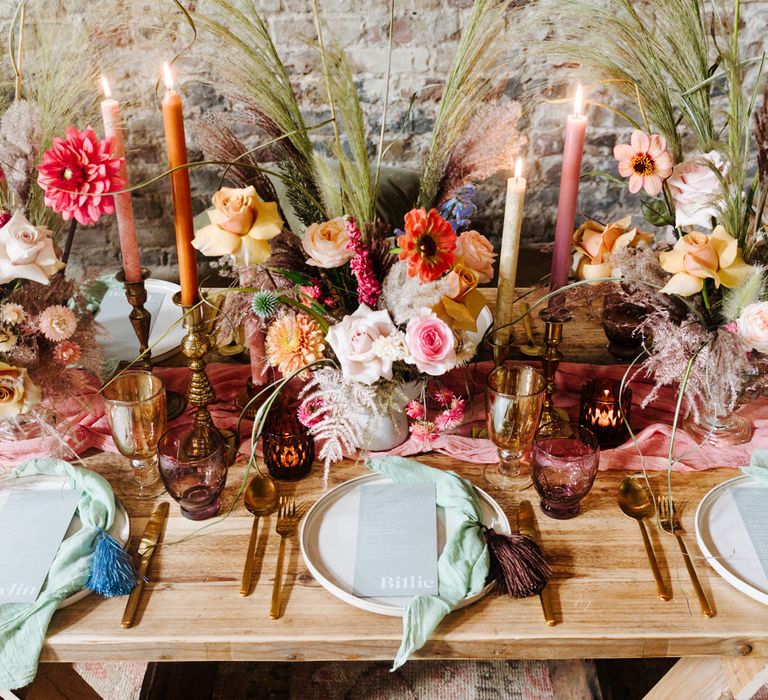 Intimate wedding table decor with bright flowers, tableware and wedding stationery 