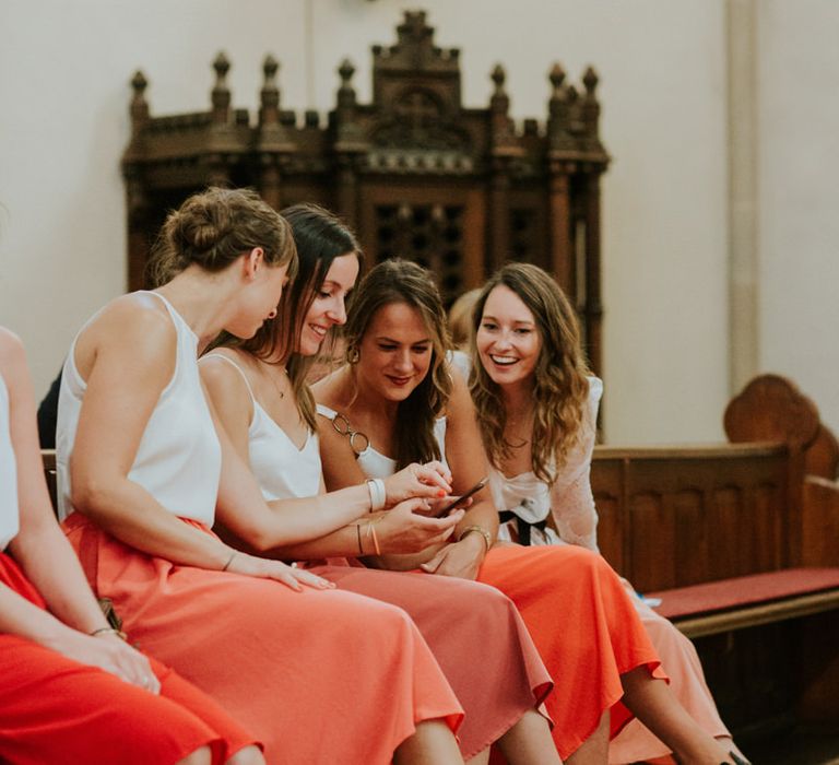 Bridesmaids in orange skirts and white tops 