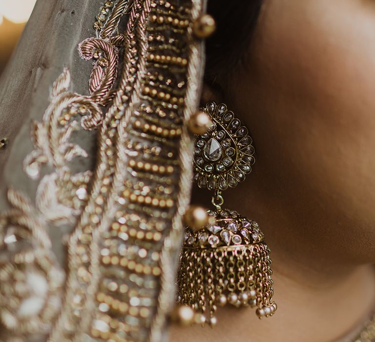 Muslim bride with gold earrings and embellished veil 