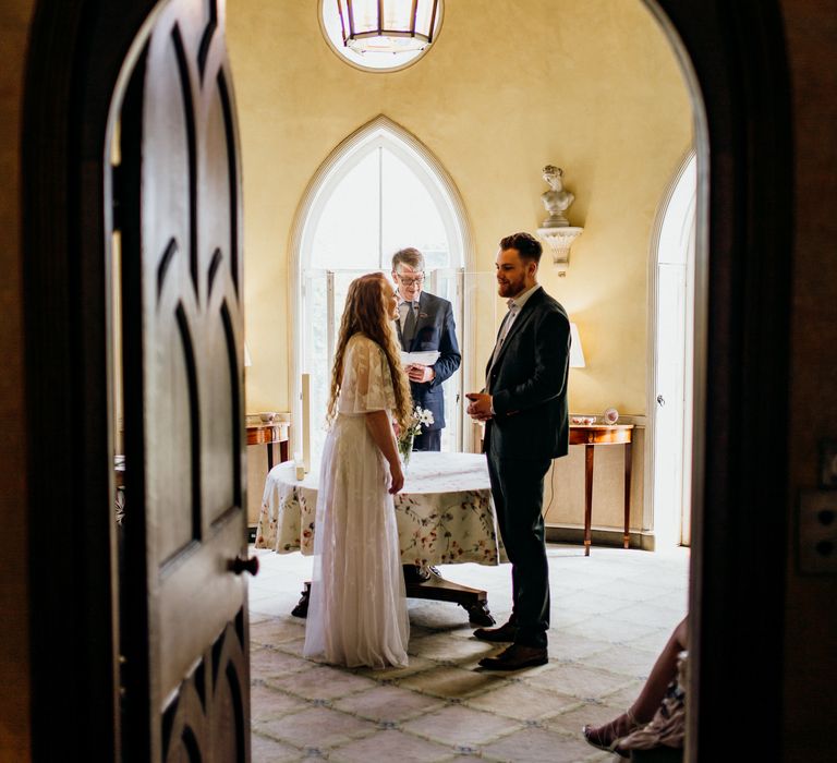 Bride & groom through doorway arch 