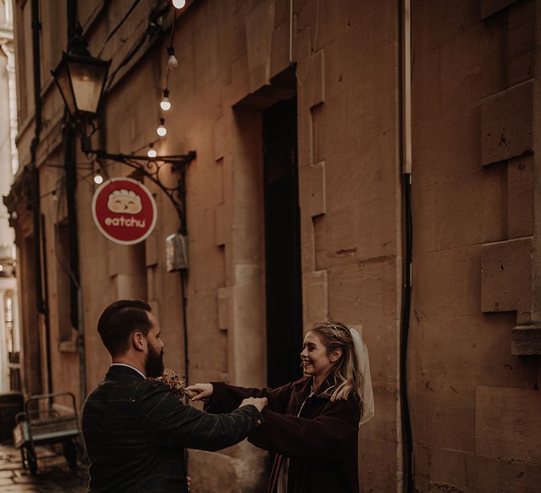 Bride and groom dance in the streets at city elopement in Bristol