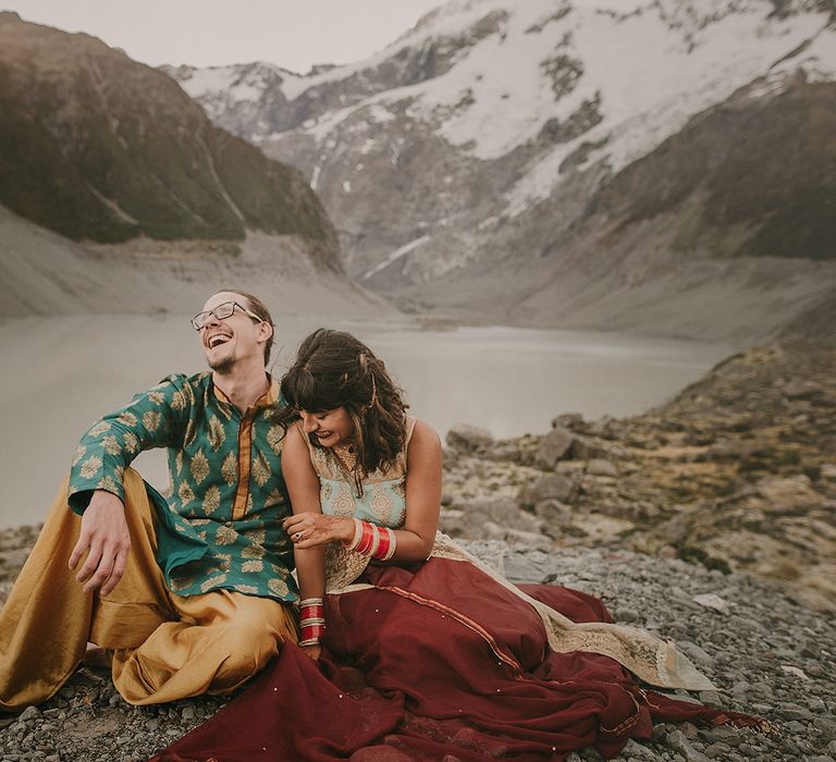 The bride and groom smiling and laughing on Mount Cook