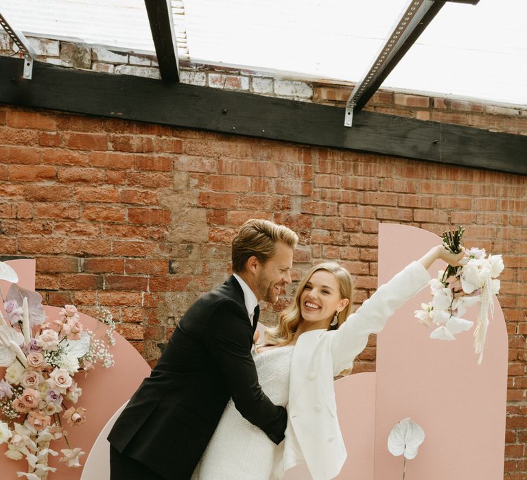 Bride and groom celebrating at the altar of The Shack Revolution with pink altar 