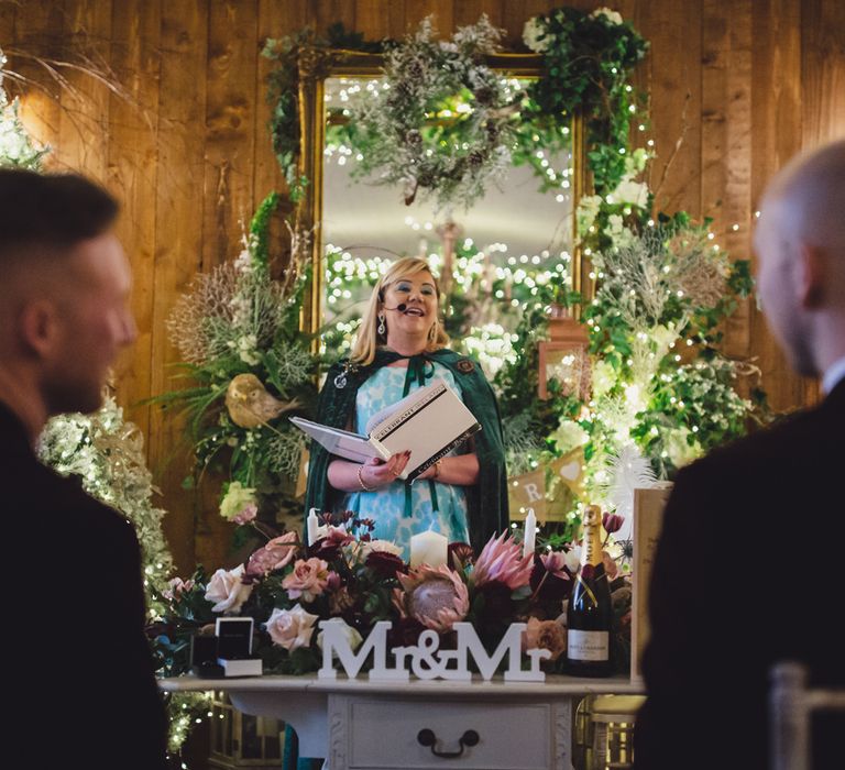 Celebrant conducting a same sex wedding at Darver Castle with foliage and fairy light decor 