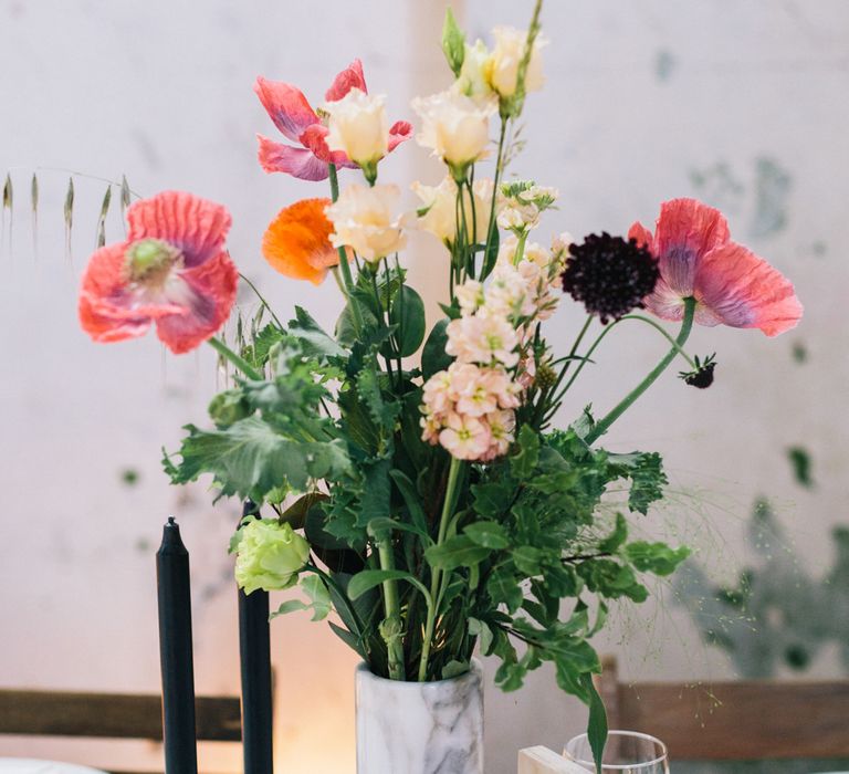 Poppy and white rose flowers in white marble vase for wedding table decor