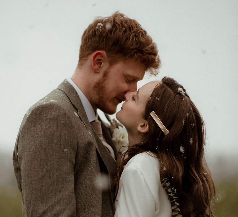 It started to snow as the bride and groom posed for wedding photos