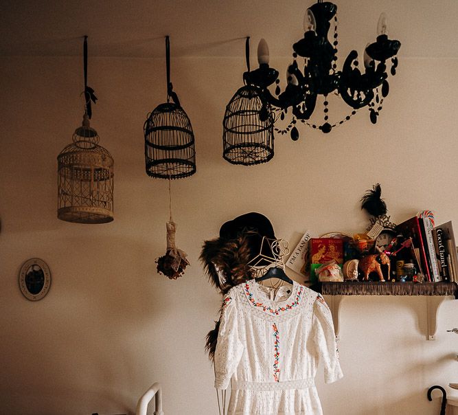 Broderie Anglaise wedding dress hanging up at home 