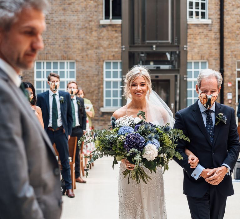 Bride walks down the aisle of Hackney Town Hall with homemade bouquet