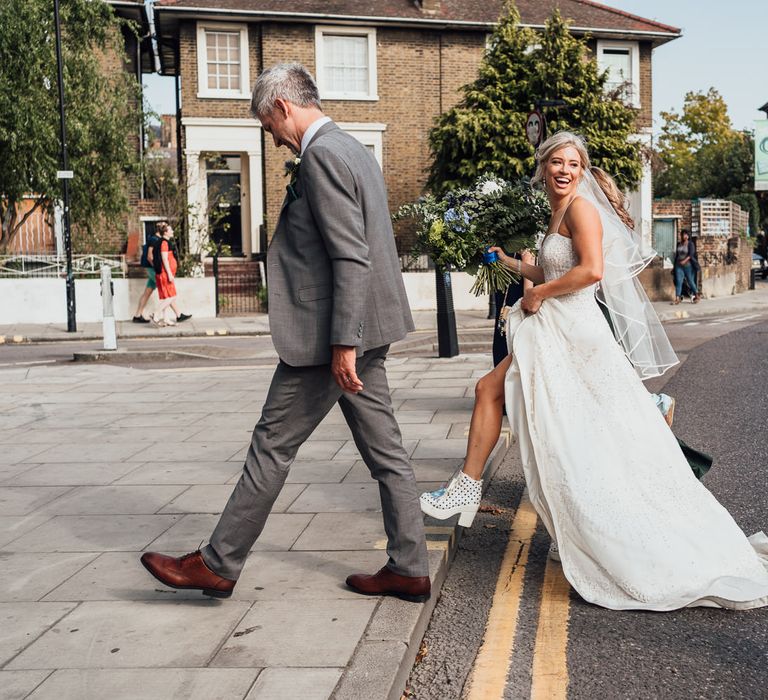 Bride & groom walk together with wedding party to reception venue