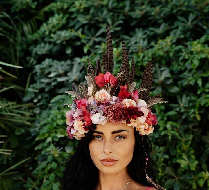 A bridesmaid in a pink jumpsuit wears an oversized flower crown for a drag race wedding inspiration shoot. Photography by Stephanie Shenton. 