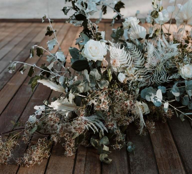 Organic neutral coloured floral arrangement for floor with white rose, white ferns and green foliage 