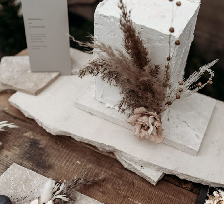 Tall square wedding cake with dried grass decor 