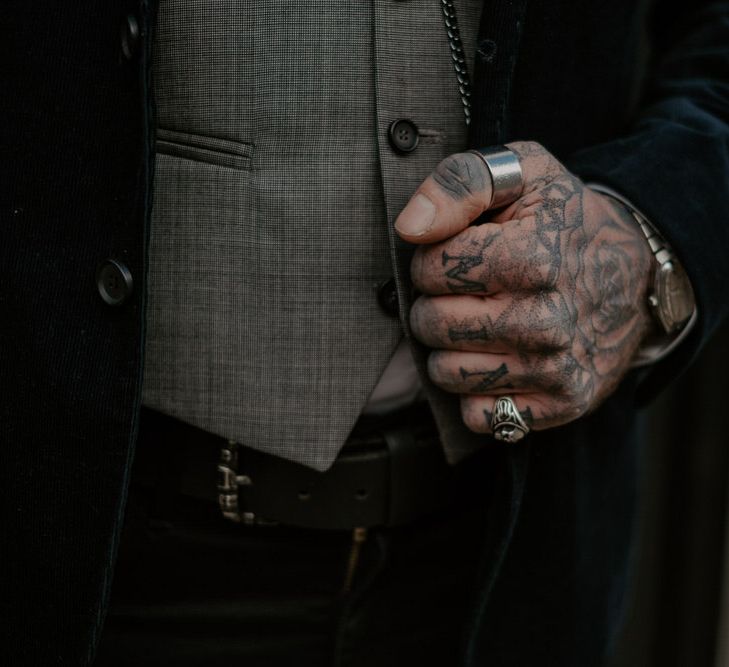 Close up of man with tattooed hand holding on to suit jacket