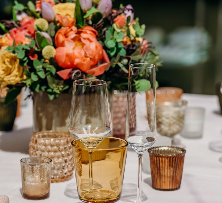 Gold cutlery on white tablecloth with wine glasses