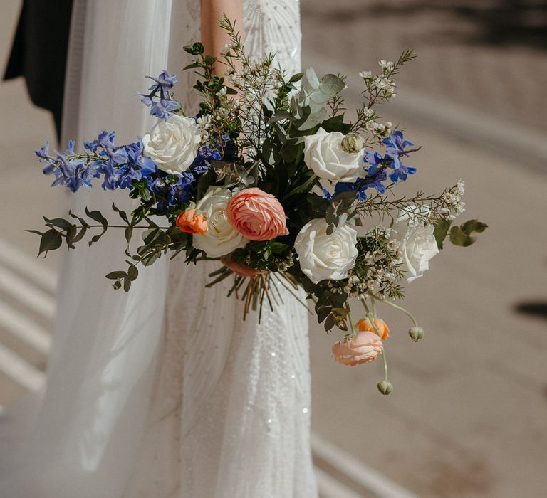 Bouquet of white, peach and blue coloured flowers with roses and eucalyptus