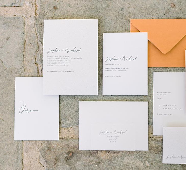 Contemporary wedding stationery suite with script font and orange envelope 