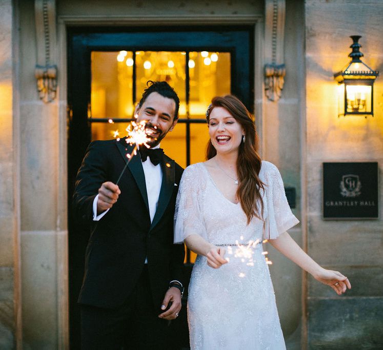 Sparkler moment for black tie wedding at Grantley Hall wedding venue in Yorkshire with groom in a tuxedo and bride in an Eliza Jane Howell embellished wedding dress 