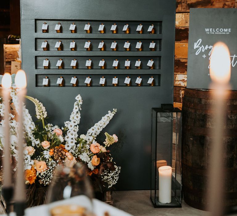 Black wedding favour stand with miniature bottles of olive oil