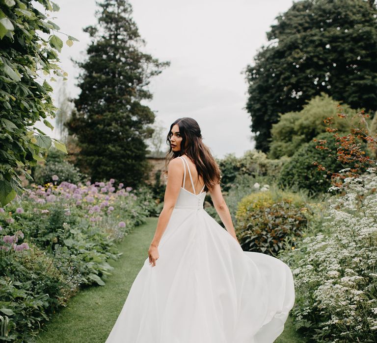 Bride in a Suzanne Neville bridal gown with double strap detail and buttons 