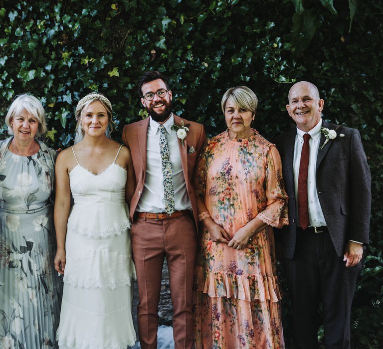 Wedding guests gather together for family photos after wedding ceremony in Cornwall