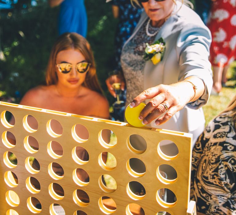 Guests play garden games for summer festival style wedding | Story + Colour