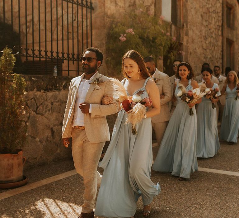 Bridesmaids prepare to walk down the aisle with groomsmen