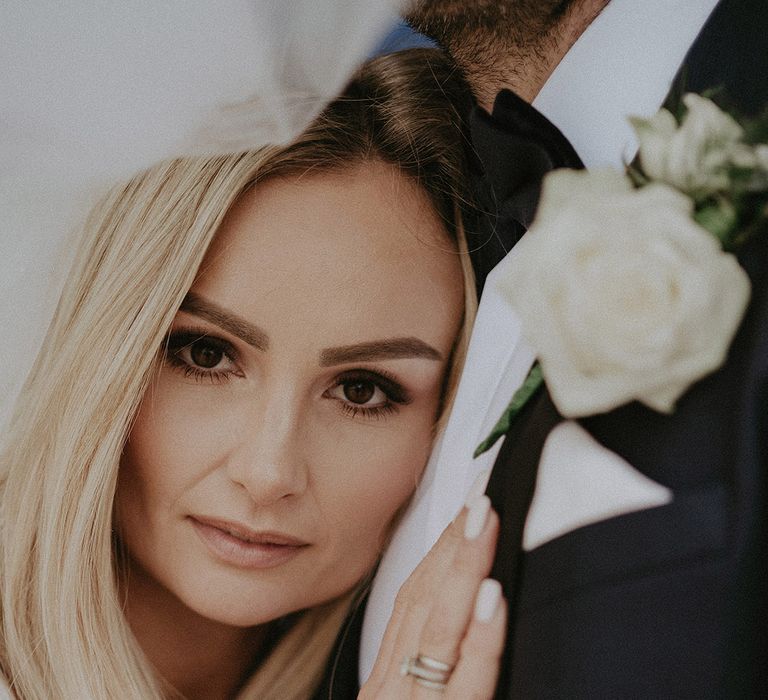 Bride with white wedding nails leans on groom