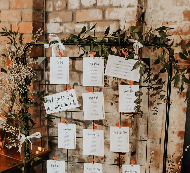 Industrial style wedding table plan with wire frame and heart shaped pegs decorated with foliage for wedding at Scale in Liverpool