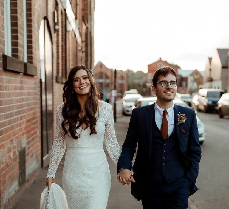 Bride and groom walk the streets together after their wedding ceremony 