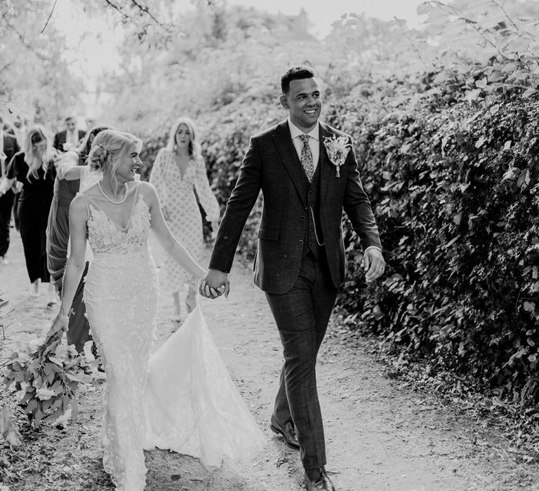 Bride and groom lead their wedding guests to the wedding reception