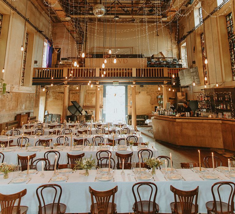 Freud reception wedding venue with fairy lights, disco balls and banquet tables with stained glass windows 