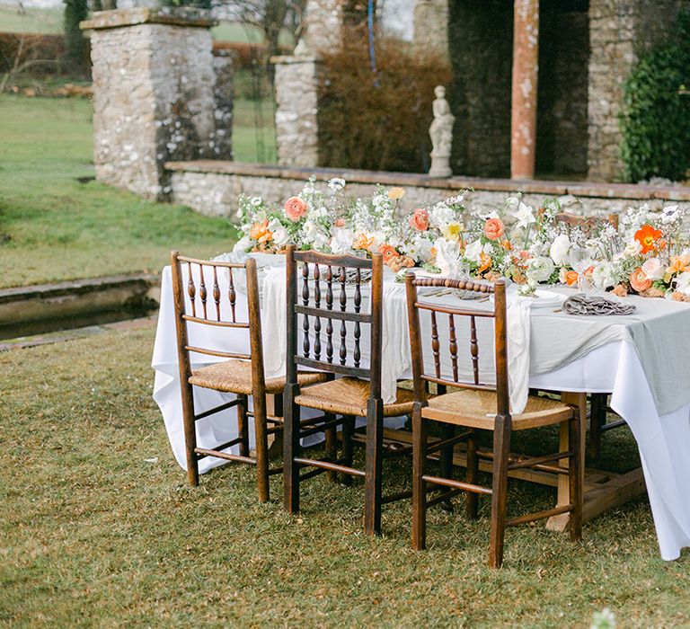 Outdoor tablescape at Holesfoot with peach nd white cascading floral centrepiece 