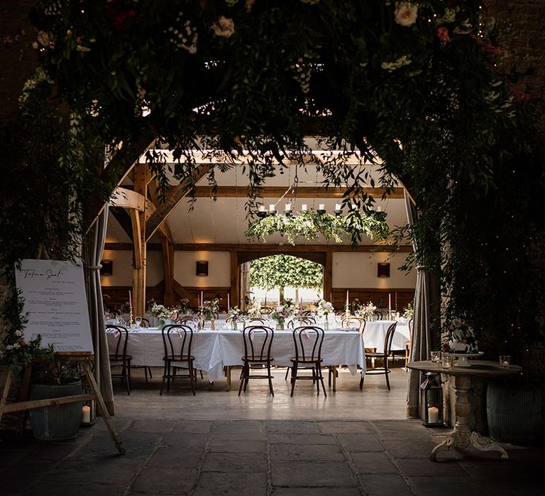 Entrance to the reception room at Cripps Barn wedding venue with lots of greenery and pink decor 