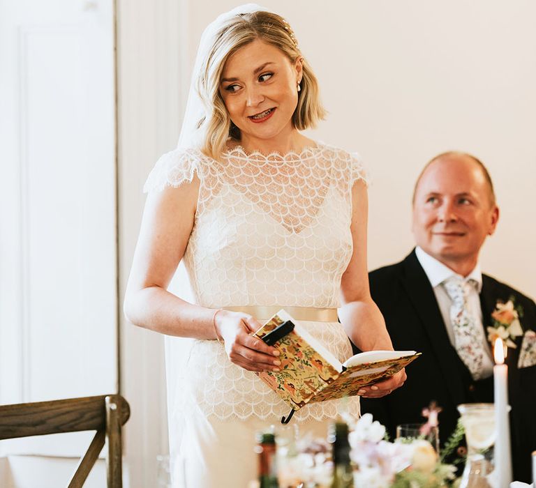 Blonde haired bride reads speech on her wedding day whilst wearing Debbie Carlisle hair pins 