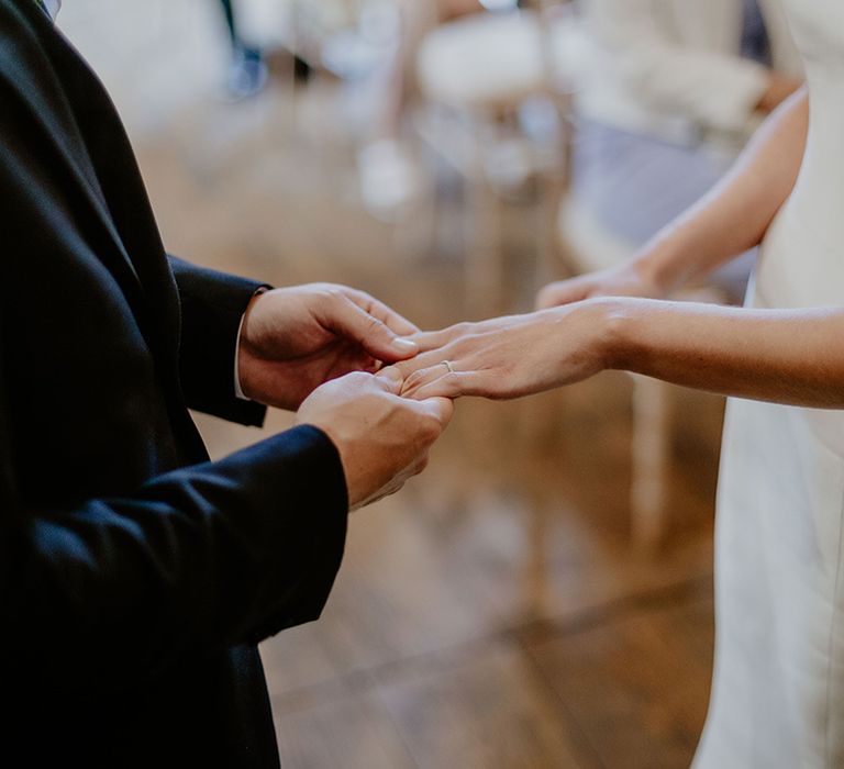 Groom puts on the bride's wedding ring for the traditional civil ceremony 