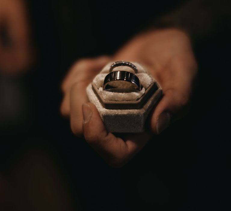 Grey velvet box with silver wedding band and silver diamond encrusted wedding band