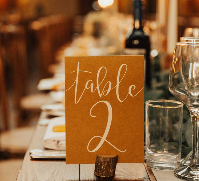 White & orange table numbers in small wooden block