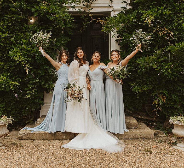 Bridesmaids in pale blue dresses with the bride at the classic Sprivers Mansion country house wedding venue 