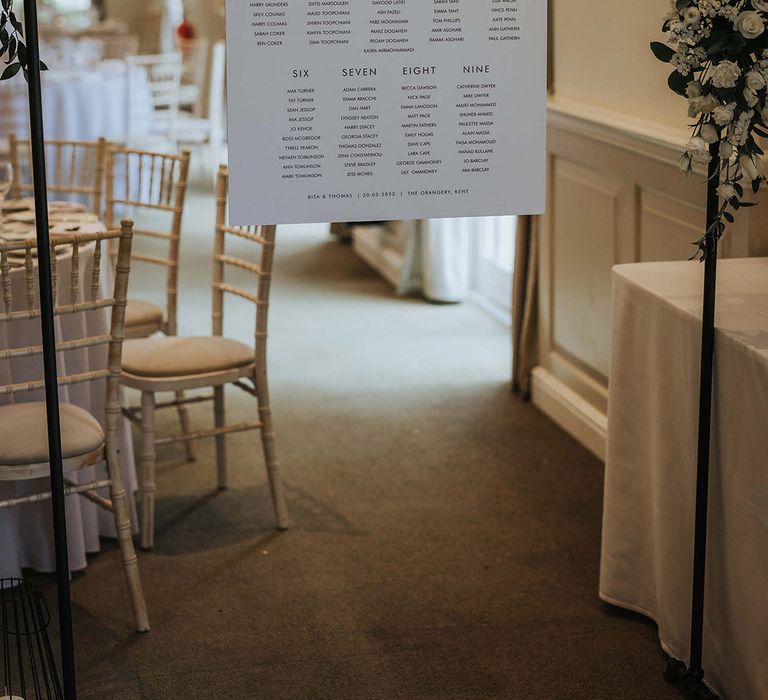 Minimal black and white wedding seating chart decorated with white roses 