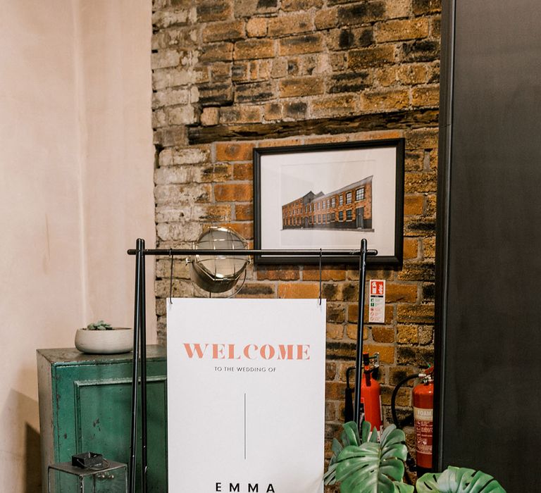 Modern styled wedding signage with industrial feel beside black lanterns complete with white pillar candles  