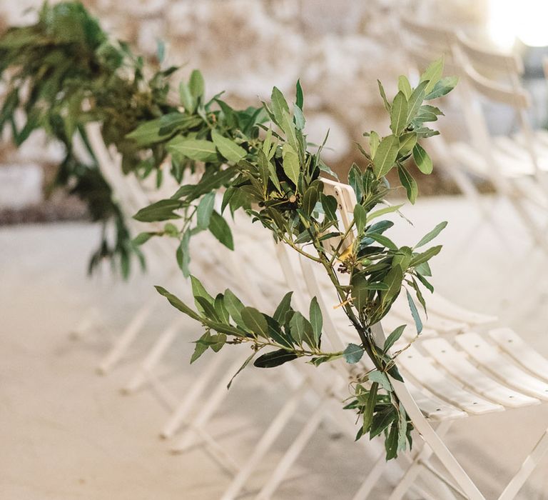 White wedding chair decorated with simple rustic foliage for a French wedding 