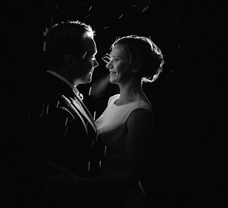 Romantic wedding portrait of the bride and groom as it rains 