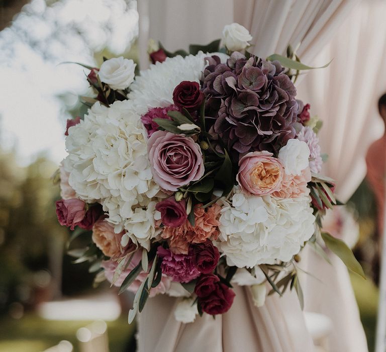 Garden rose, peony, eucalyptus and dried flower bridal bouquet on wedding mandap 