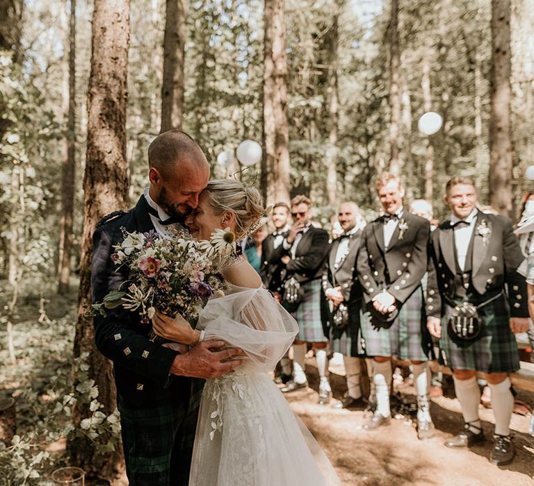 The bride and groom have an emotional embrace together at the altar for their humanist outdoor woodland wedding 