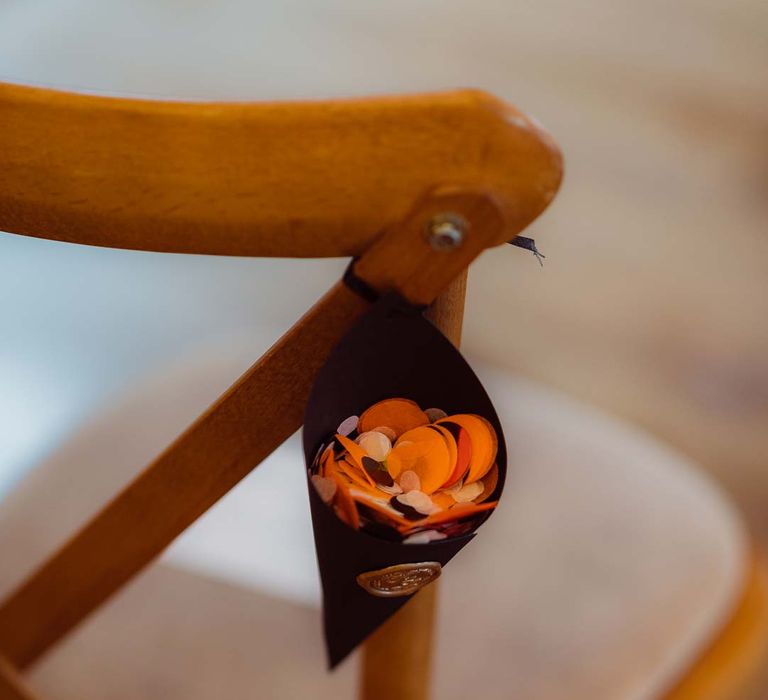 Confetti cone on the back of wooden chair at Kingscote Barn Tetbury wedding venue 